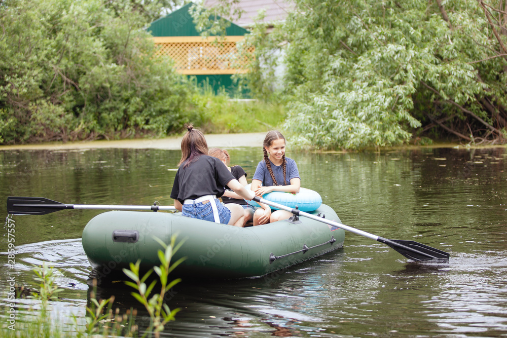 Children ride an inflatable boat on the lake Children ride an inflatable boat on the lake