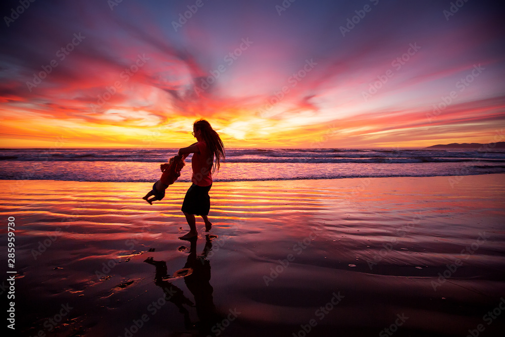 mother and son having fun at sunset on the beach mother and son having fun at sunset on the beach