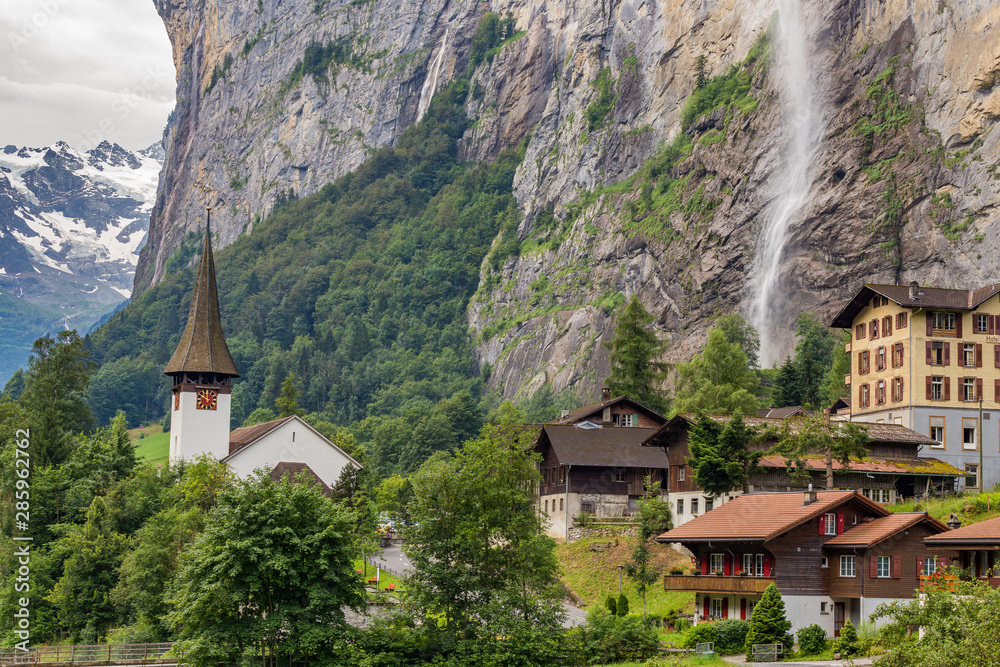 Amazing view of famous Lauterbrunnen town in Swiss Alps valley with beautiful Staubbach waterfalls in the background, Switzerland