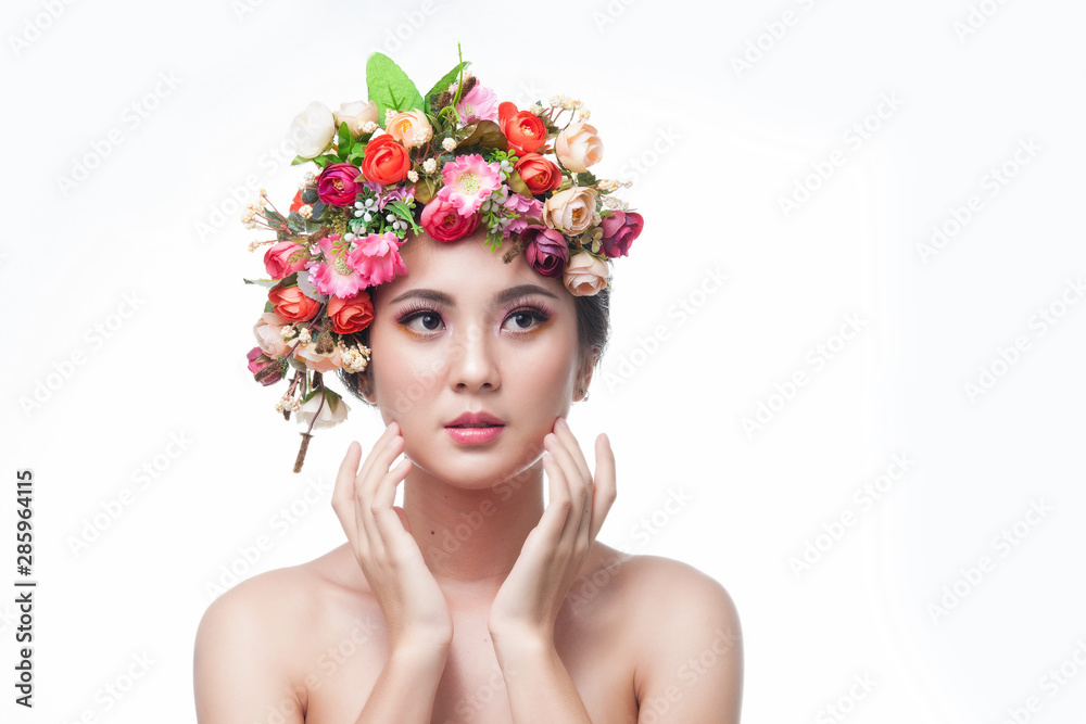 Portrait of beautiful young asian woman with flowers and skin care.