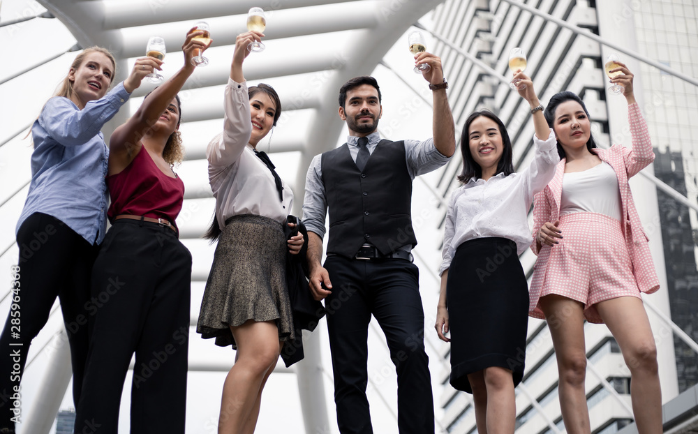 Group of business people celebrate by drinking wine.