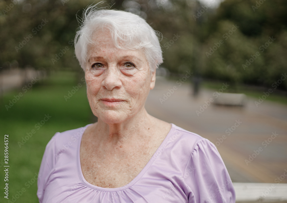 Photo portrait of an old woman in a park on a warm day Photo portrait of an old woman in a park on a warm day