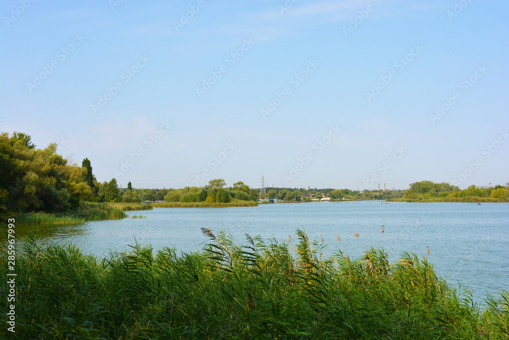 Beautiful view of the Samara River with picturesque steep banks and coast, trees, greenery and rich sky. Bright and unforgettable nature in the housing estate, Shevchenko, Dnipro, Ukraine.