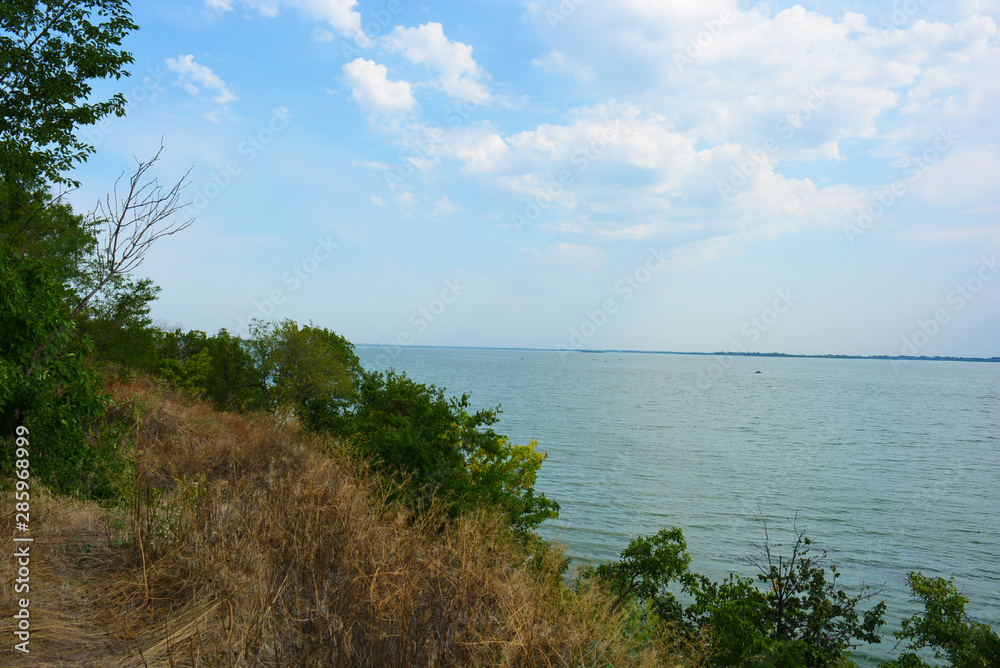 Beautiful view of the Samara River with picturesque steep banks and coast, trees, greenery and rich sky. Bright and unforgettable nature in the housing estate, Shevchenko, Dnipro, Ukraine. Beautiful view of the Samara River with picturesque steep banks and coast, trees, greenery and rich sky. Bright and unforgettable nature in the housing estate, Shevchenko, Dnipro, Ukraine.