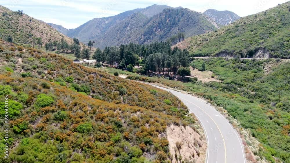 Asphalt road bends through Angeles National forests mountain, California, USA. Thin road winds between a ridge of hills and mountains at high altitude Asphalt road bends through Angeles National forests mountain, California, USA. Thin road winds between a ridge of hills and mountains at high altitude