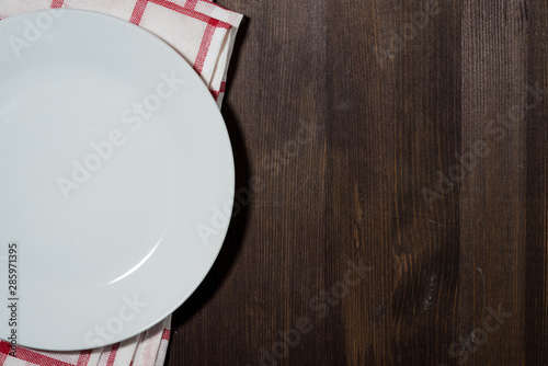 empty plate on a kitchen napkin, wooden background for recipes