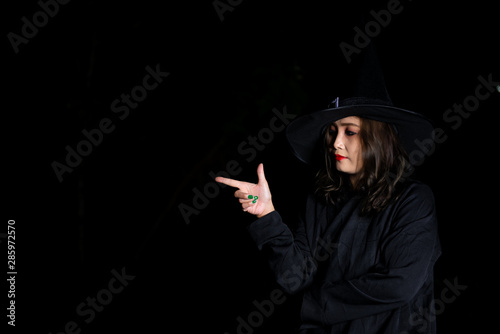 Portrait of beautiful asian woman wear witch costume on black background,Thailand people,Halloween festival concept,Horror scene