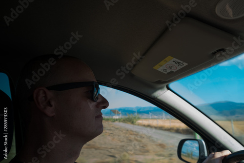 Truck driver with sunglasses working hard in a sunny day