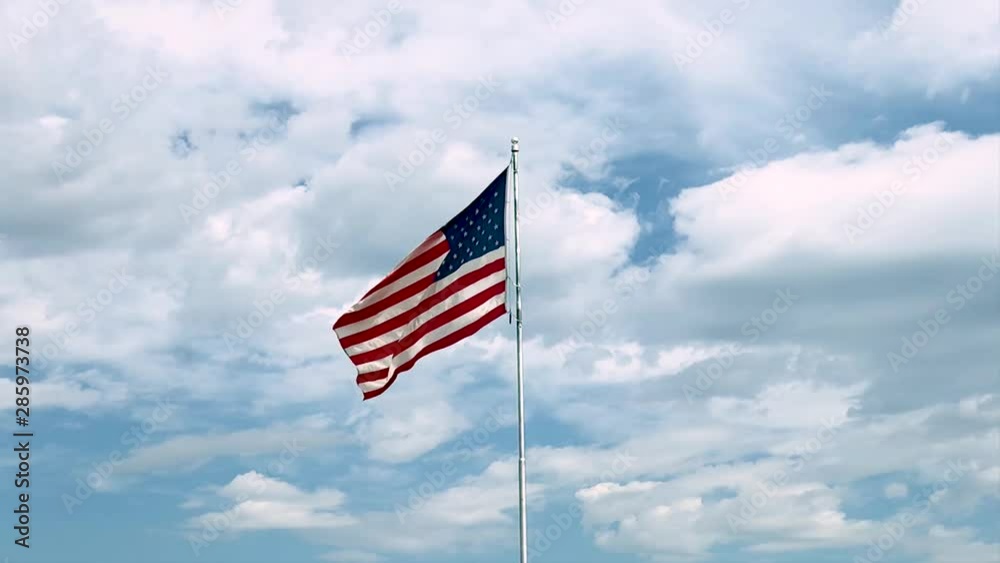 american flag waving in the wind against blue sky slow motion american flag waving in the wind against blue sky slow motion