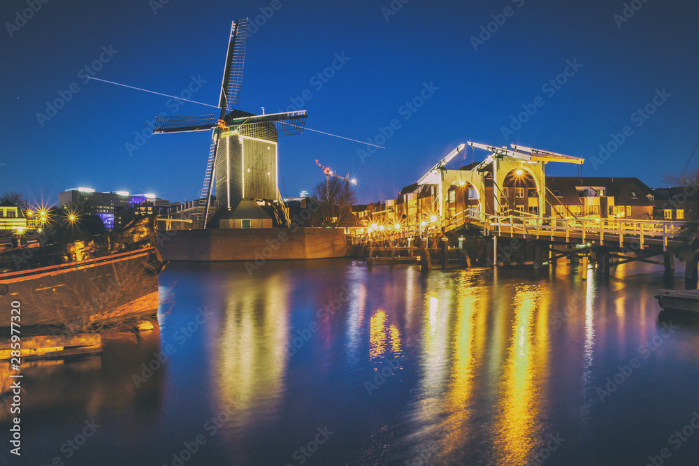 Cityscape - evening view of the city canal with drawbridge and windmill, the city of Leiden, Netherlands.