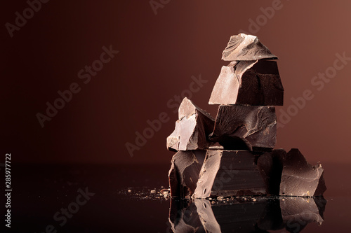 Pieces of dark chocolate on a dark background.