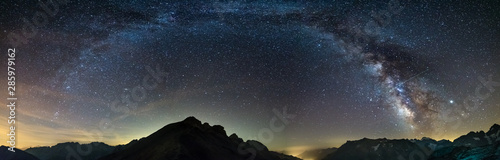 Droga Mleczna wygina się gwiaździste niebo w Alpach, Massif des Ecrins, ośrodek narciarski Briancon Serre Chevalier, Francja. Panoramiczny widok na wysokie góry i lodowce, fotografia astro, obserwacja gwiazd