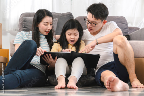 happiness asian family dad mom daughter sit relax enjoy watching tablet together with fun and exited
