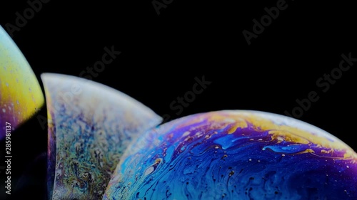 Macro shot of a soap bubble creates a colorful and black background