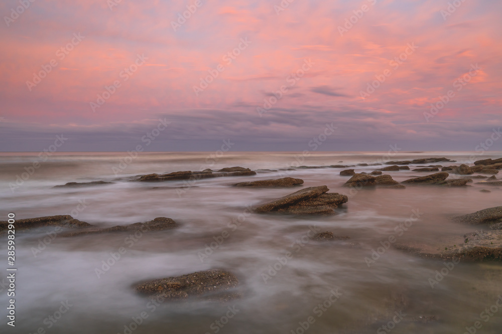 Long exposure seascape background of a painterly sunset on a Florida beach.