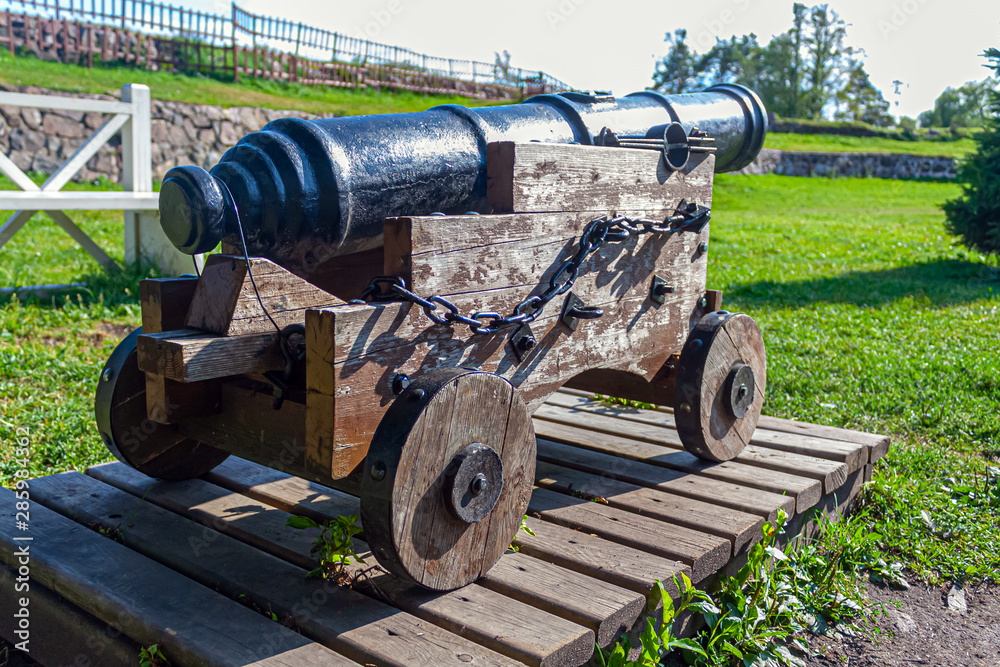 old cast-iron cannon on a wooden carriage in the Karela fortress on a summer day close-up