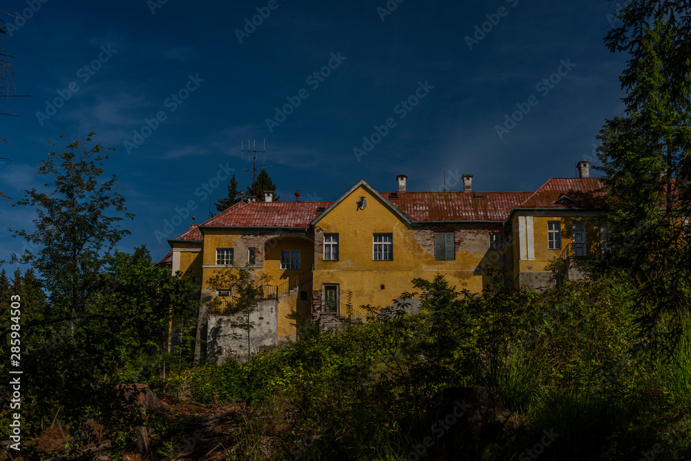 Old hunting castle in forest in Krusne mountains in summer sunny day with creek