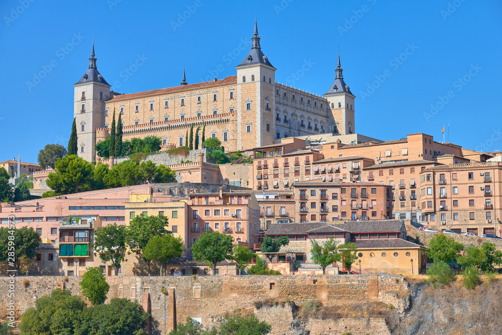 Colorful cityscape view of the Alcazar fortification castle at the highest part of the medieval walled city of Toledo, Castilla la Mancha, Spain. UNESCO world heritage site.