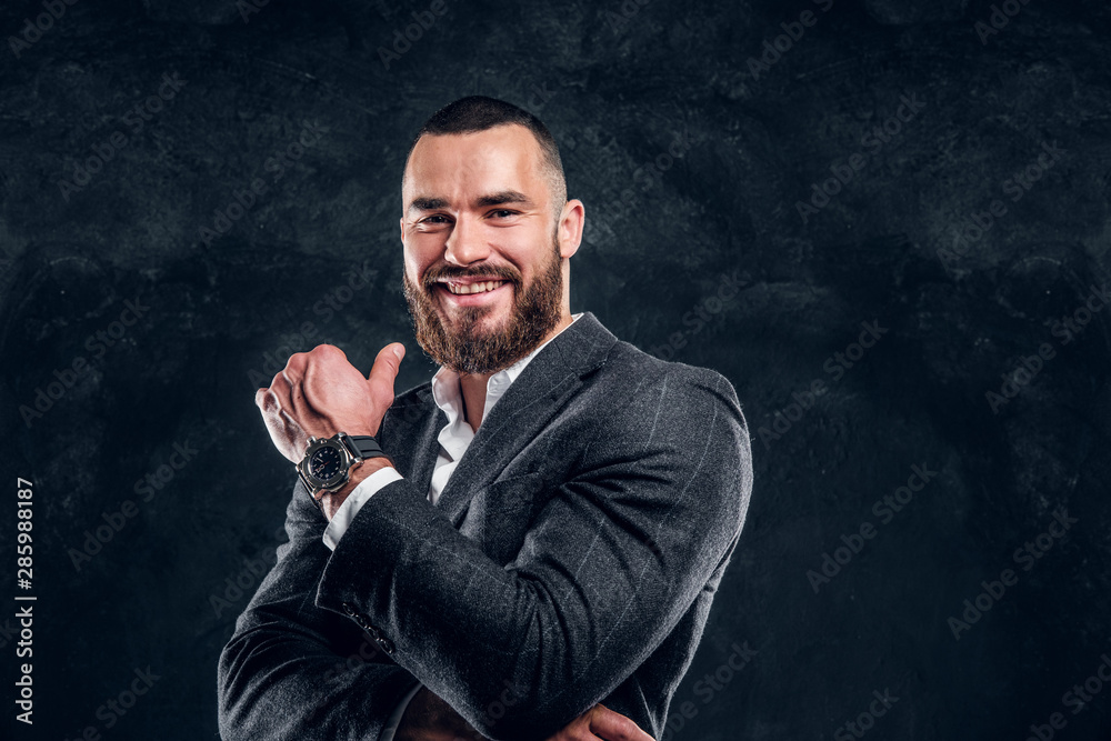 Happy smiling man in suit and white shirt is posing for photographer at dark studio. Happy smiling man in suit and white shirt is posing for photographer at dark studio.