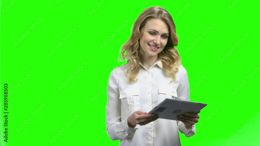 Cheerful business woman with digital tablet on green screen. Young pretty woman speaker welcoming audience with spreading hands. Chroma Key background. Cheerful business woman with digital tablet on green screen. Young pretty woman speaker welcoming audience with spreading hands. Chroma Key background.