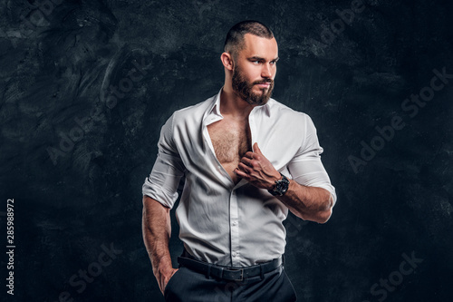 Fotografía Sucessful bearded businessman in white shirt is feeling hot at dark photo studio