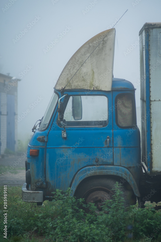 blue truck in the early foggy morning