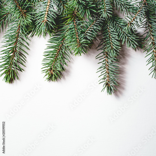 Fir branches on white wooden background. Christmas wallpaper. Flat lay  copy space.