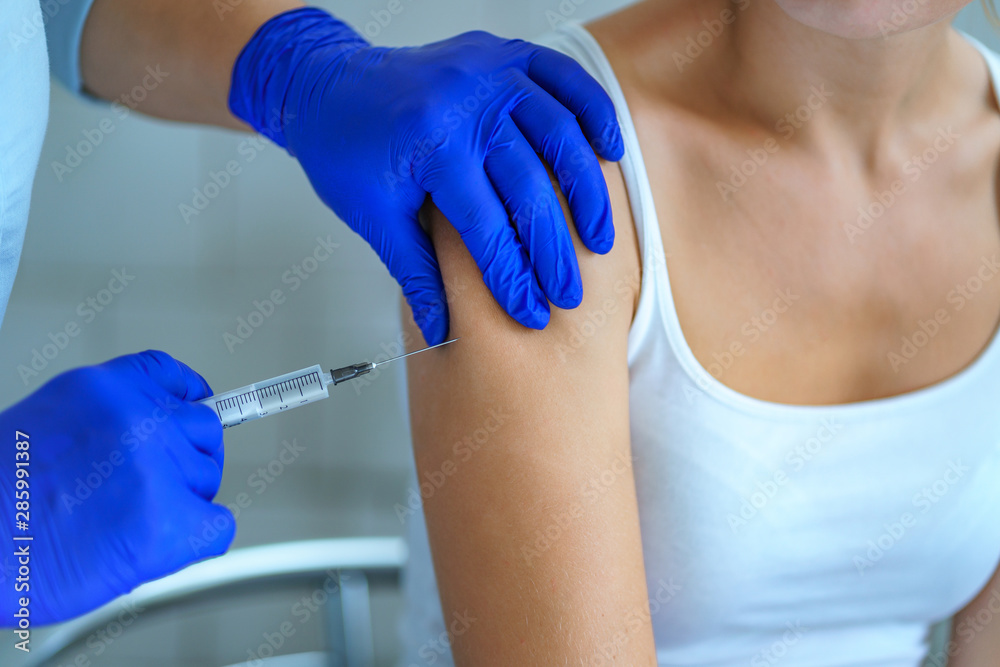 A nurse vaccinates a patient in hospital during an epidemic of influenza, measles and viral infections A nurse vaccinates a patient in hospital during an epidemic of influenza, measles and viral infections