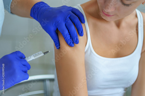 A nurse vaccinates a patient during an epidemic of influenza, measles and viral infections