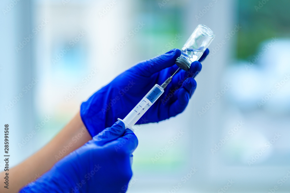 Vaccine during flu and measles epidemic. Prevention viral infectious diseases. Using syringe for injection of an antibiotic to a patient in a hospital. Flu shot close-up Vaccine during flu and measles epidemic. Prevention viral infectious diseases. Using syringe for injection of an antibiotic to a patient in a hospital. Flu shot close-up