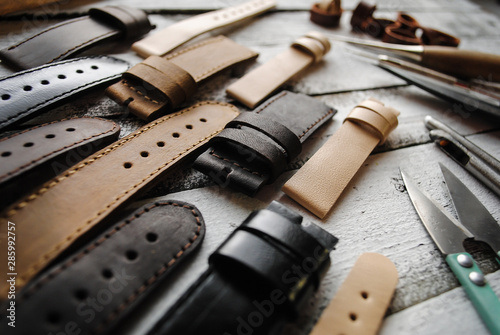 Metal tools and watch straps are on the table.