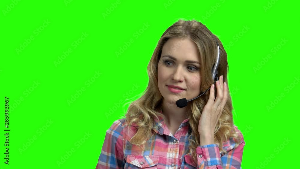Beautiful consultant of call center on green screen. Female technical support operator in headset talking with client. Chroma Key background. Beautiful consultant of call center on green screen. Female technical support operator in headset talking with client. Chroma Key background.