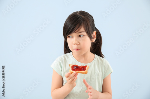Funny little girl eating ta...
