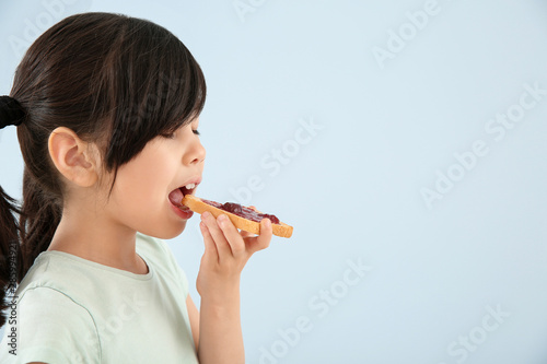 Funny little girl eating ta...