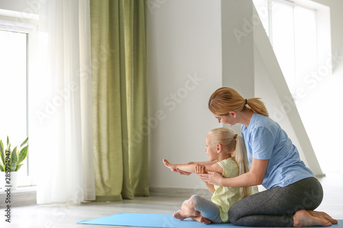 Mother helping her little g...