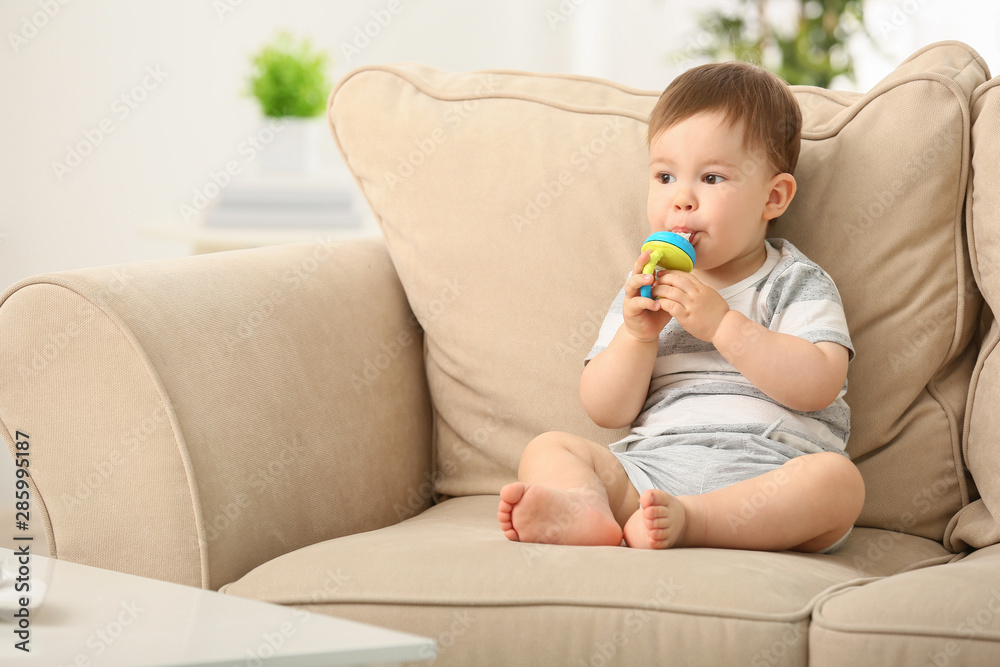 Cute little boy with nibbler sitting on sofa at home Cute little boy with nibbler sitting on sofa at home