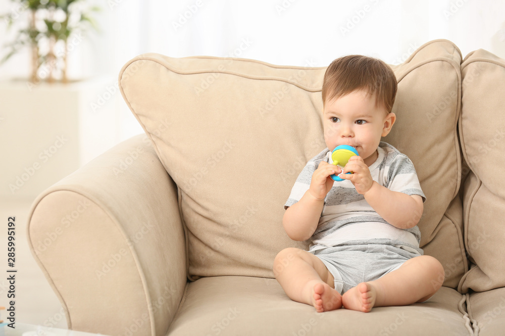 Cute little boy with nibbler sitting on sofa at home Cute little boy with nibbler sitting on sofa at home