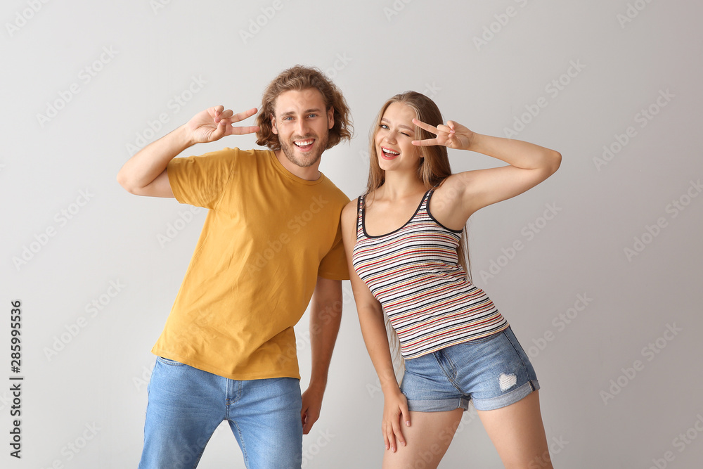 Cool young couple dancing against white background