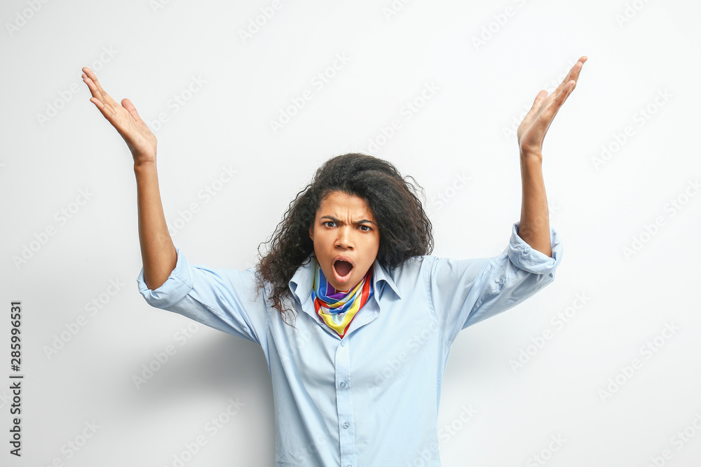 Angry young African-American woman on light background Angry young African-American woman on light background
