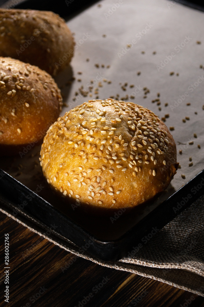 Homemade buns on burlap on wooden background