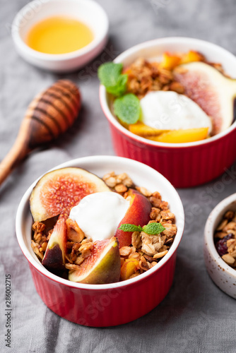 Figs, peach, granola and natural yogurt in bowl for healthy and delicious dessert or breakfast