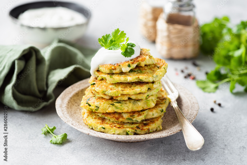 Vegetarian zucchini fritters or pancakes stack topped with sour cream and cilantro. Vegetable pancakes Vegetarian zucchini fritters or pancakes stack topped with sour cream and cilantro. Vegetable pancakes