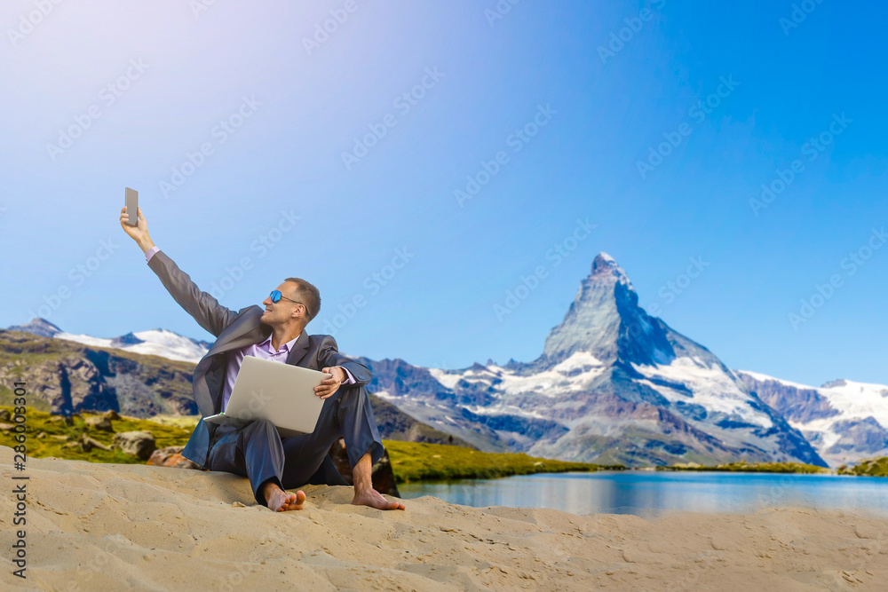 Fototapeta premium Man with laptop on the top of mountain