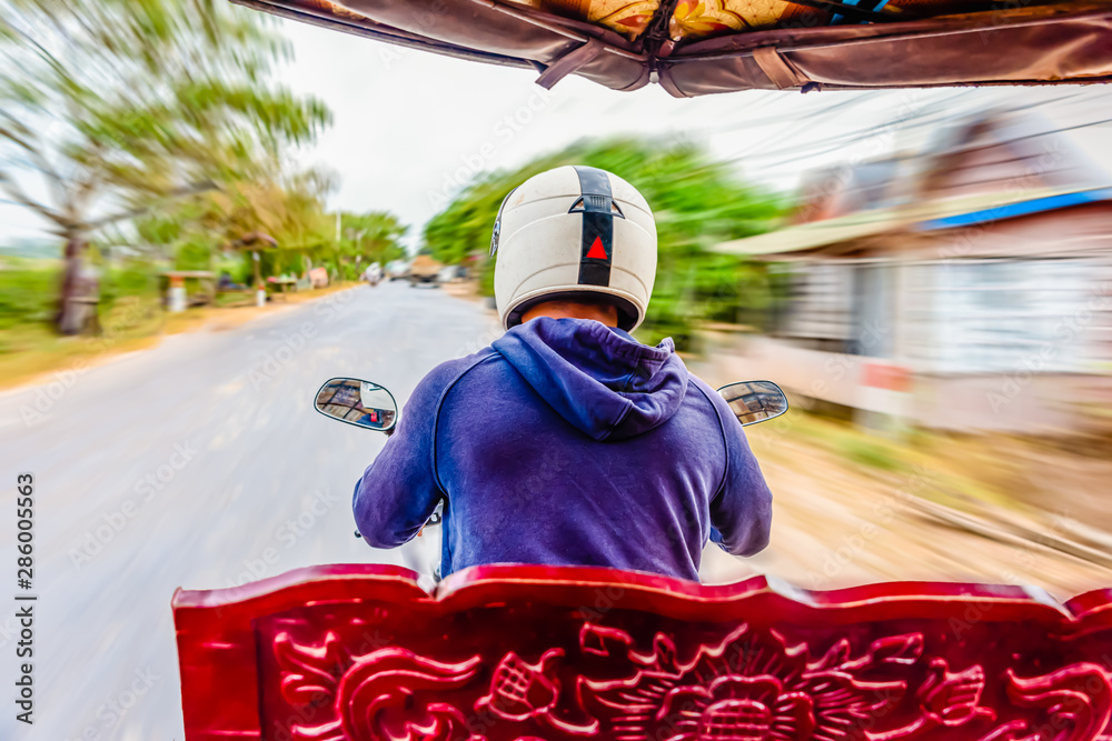 Riding in a tuk-tuk, a motorcycle with a trailer attached for transporting passengers, the de-facto taxi in Cambodia and most of South East Asia, Siem Reap, Cambodia