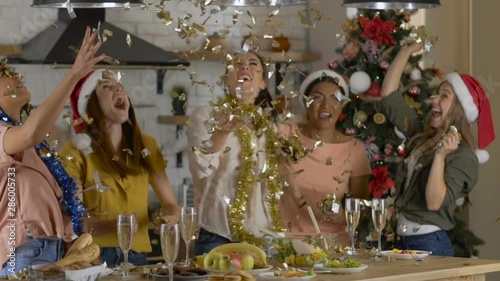 Wallpaper Mural 5 girlfriends celebrate the New Year Christmas and toss up confetti. cozy dining room in a large house. Slow motion Torontodigital.ca