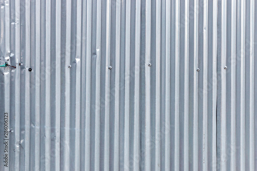 A close up view of a metal fence protecting the base of a new construction building