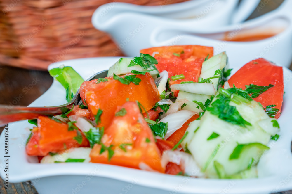 Tomato and cucumber salad with onion, pepper and parsly Tomato and cucumber salad with onion, pepper and parsly
