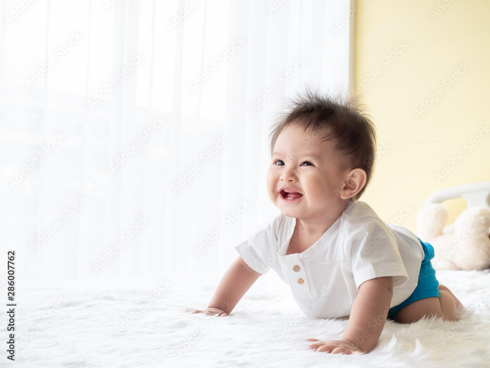 Portrait happy baby boy is crawling on white carpet in the room. Asian baby boy is crawling and smiling. Portrait happy baby boy is crawling on white carpet in the room. Asian baby boy is crawling and smiling.