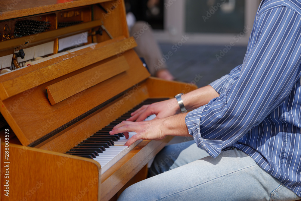 Close-up outdoor view of street artist's hand play the old vintage wooden  piano on walking street in Europe. Pianist show street performance. Stock  Photo | Adobe Stock