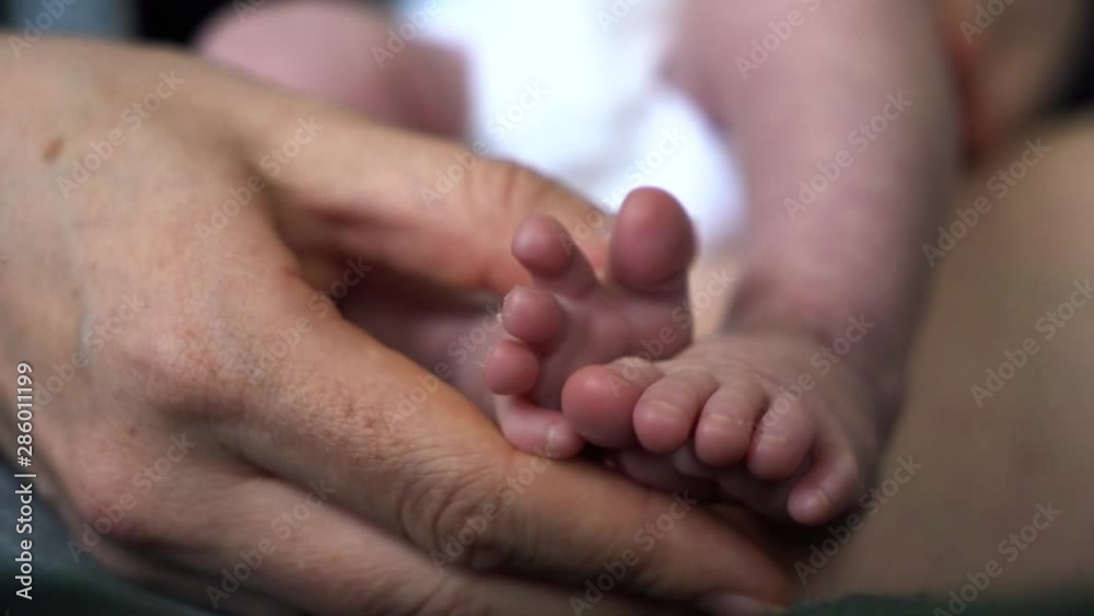 Small funny little feet of baby. Tiny Newborn Baby's feet closeup in mother hands. Small funny little feet of baby. Tiny Newborn Baby's feet closeup in mother hands.